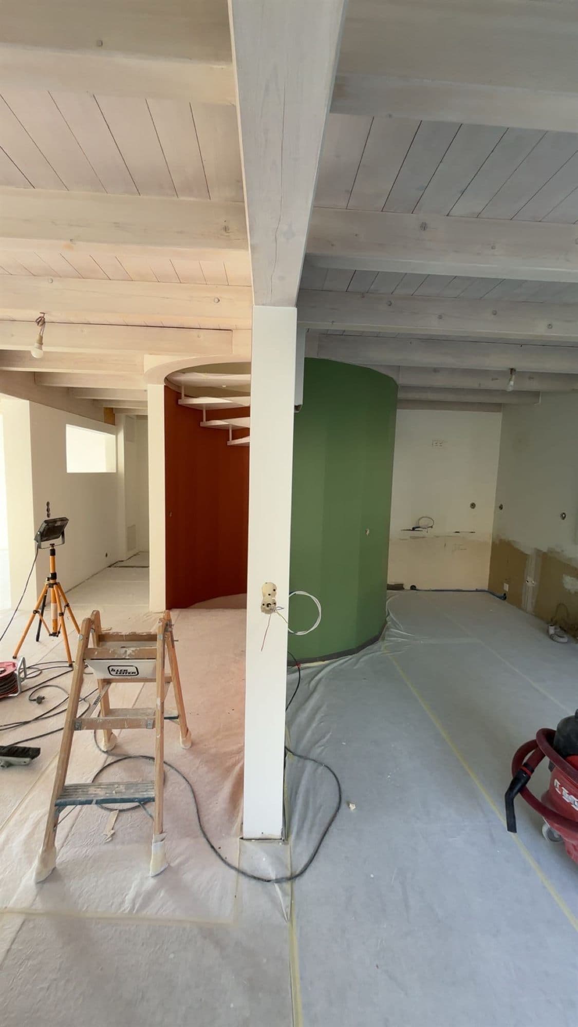 Cuisine en chantier : sols protégés, cloisons courbes fraîchement mises en teinte