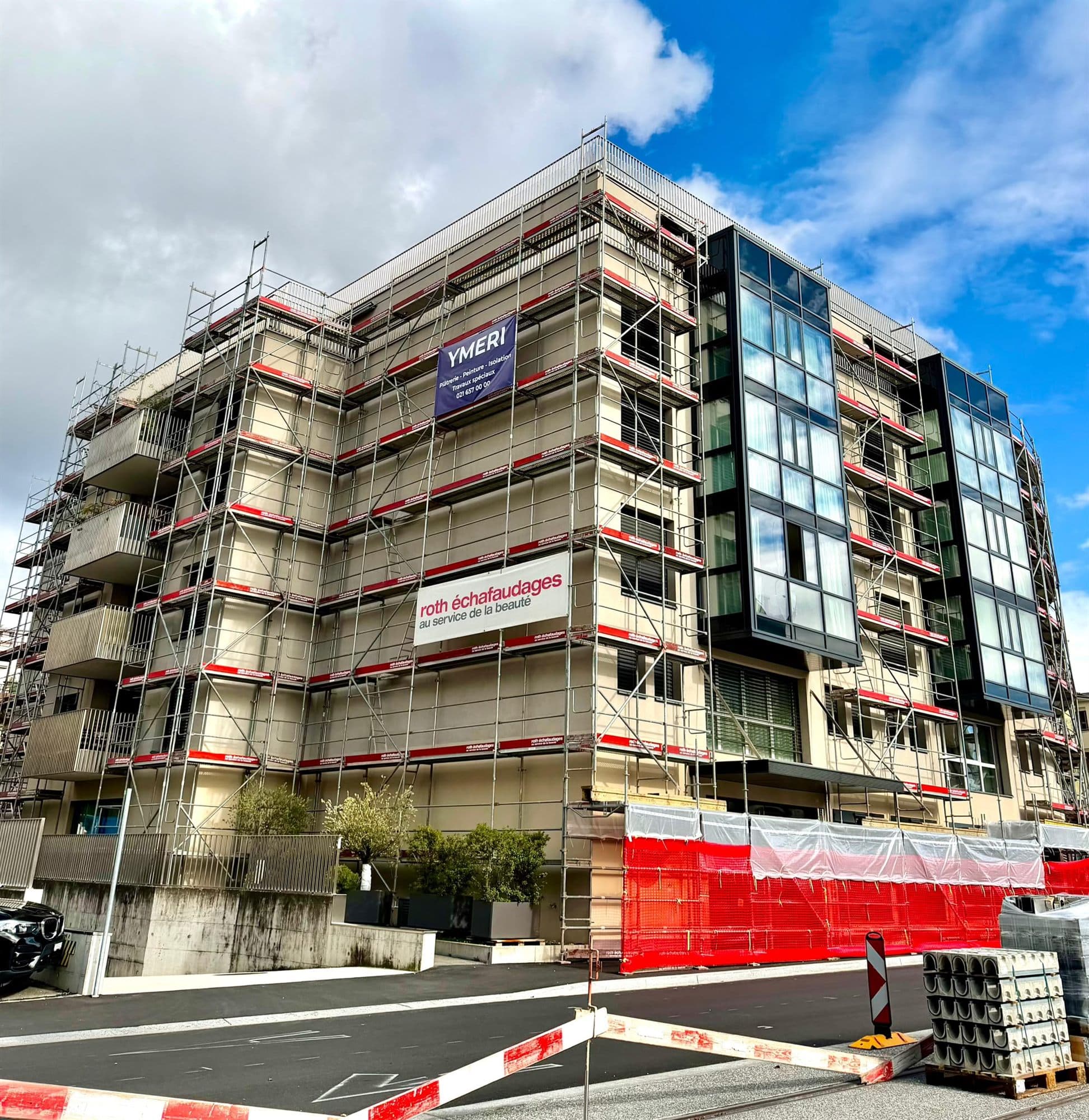 Immeuble entièrement échafaudé pendant les travaux de façade, bâche YMERI en place